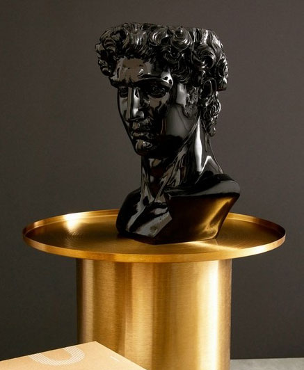 Black Olympus head bust on a goldern side table.