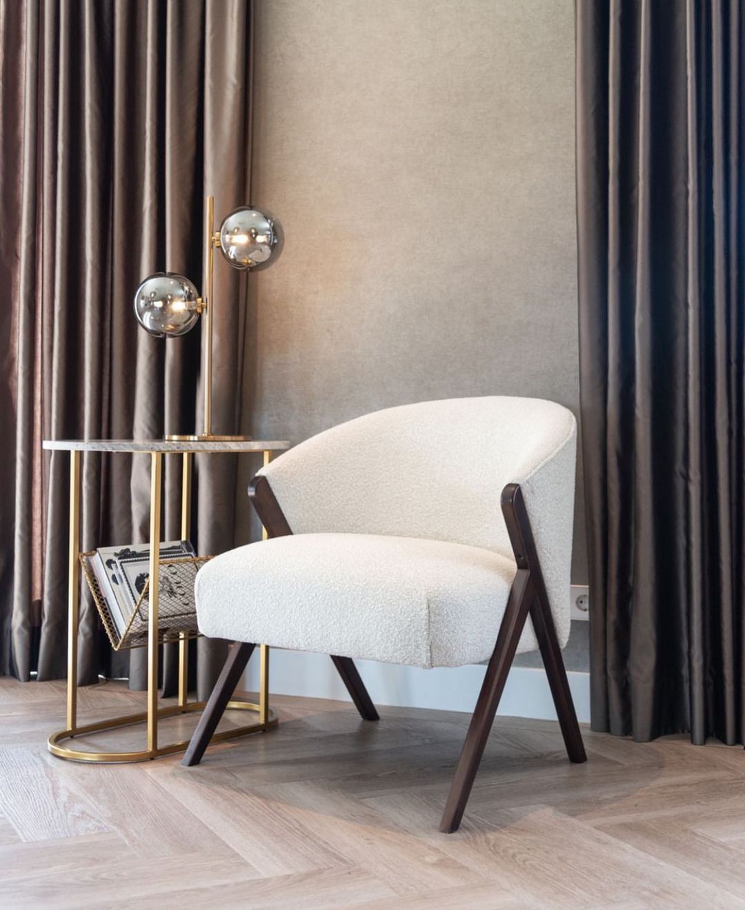 White modern armchair near a golden side table.