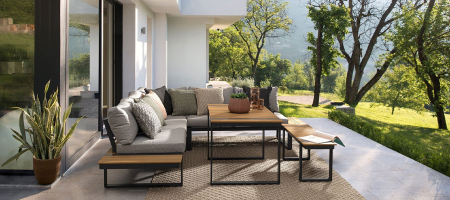 An elegant and comfortable outdoor furniture set featuring a modern design. The set includes a spacious sofa, two armchairs, and a coffee table. The furniture is made of durable weather-resistant materials and is adorned with plush cushions in a neutral c